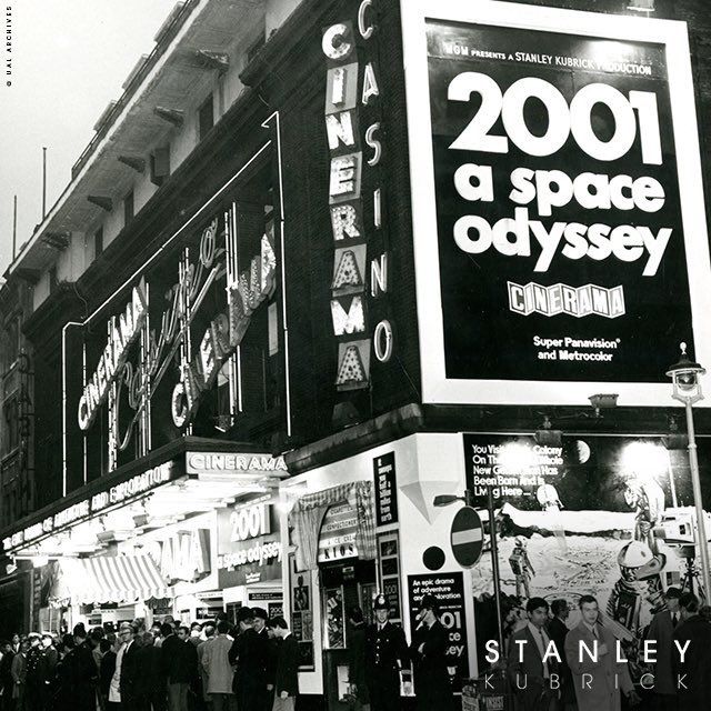 an old black and white photo of people on the street in front of a building