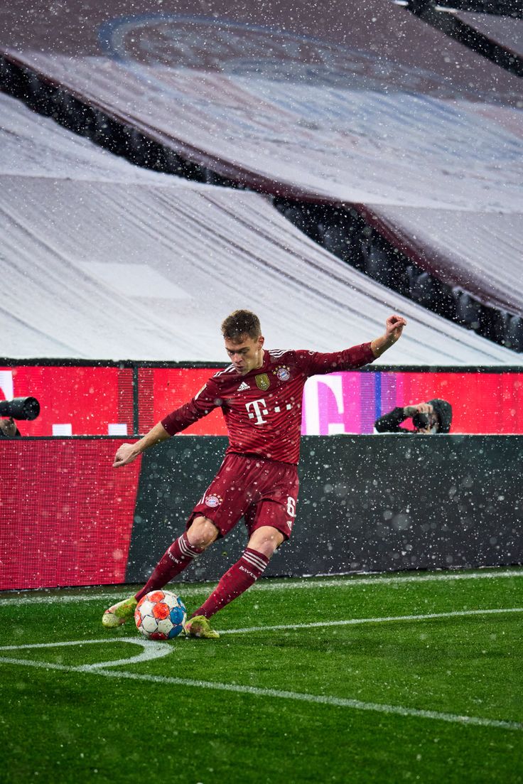 a soccer player in action on the field during a snow storm at an indoor stadium