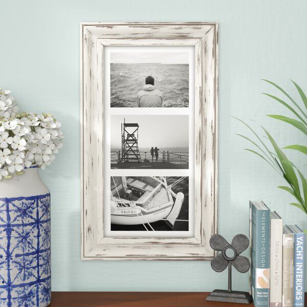 a vase with flowers sitting on top of a wooden table next to a framed photo