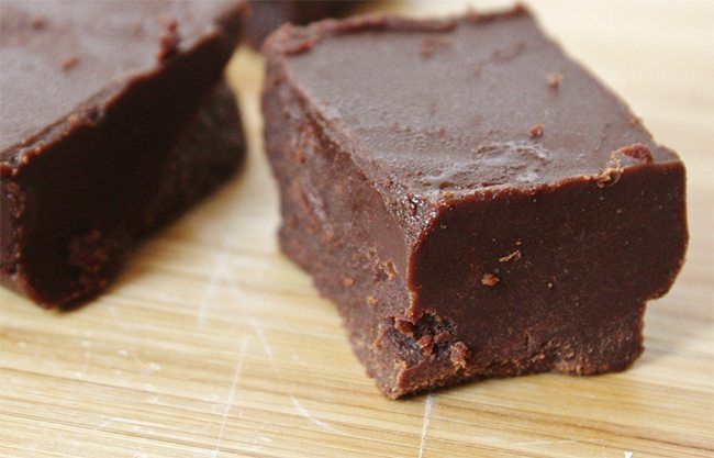 three pieces of brownie sitting on top of a wooden cutting board