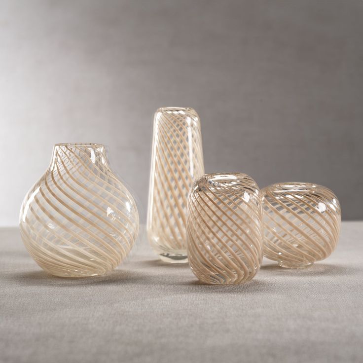 three glass vases sitting next to each other on a table