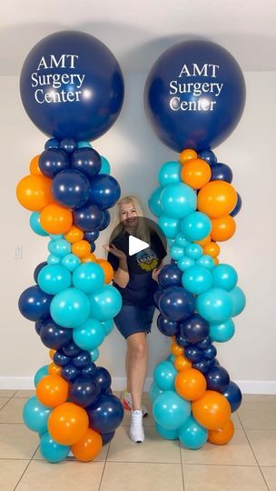 a woman sitting in front of two giant balloons with the words amt surgery center on them