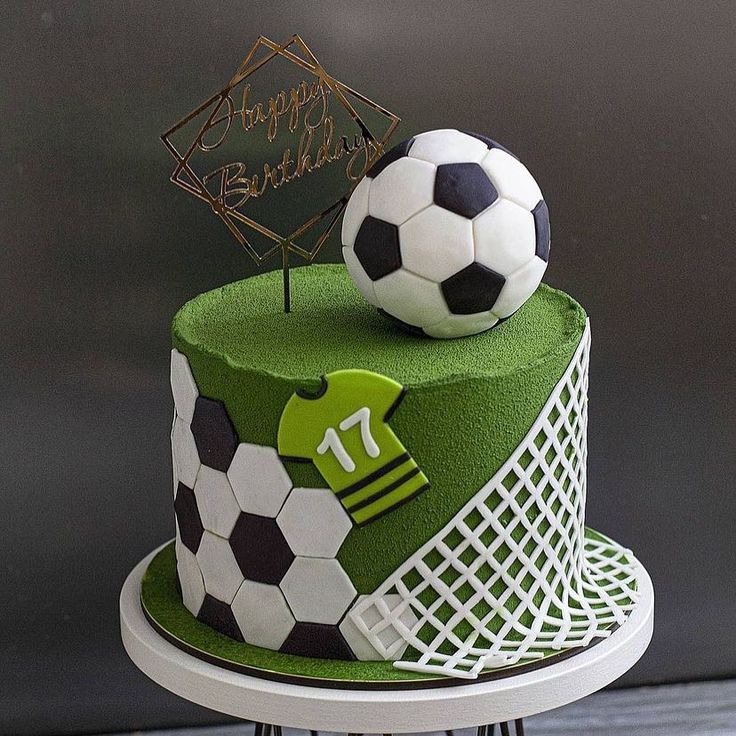 a soccer themed birthday cake with a soccer ball on top