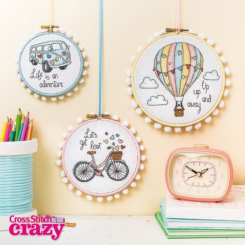 three cross stitch hoops hanging on the wall with different designs and words in them