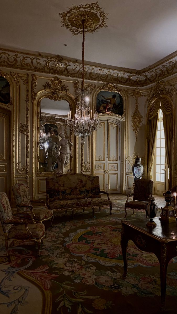 an ornate living room with chandelier and couches