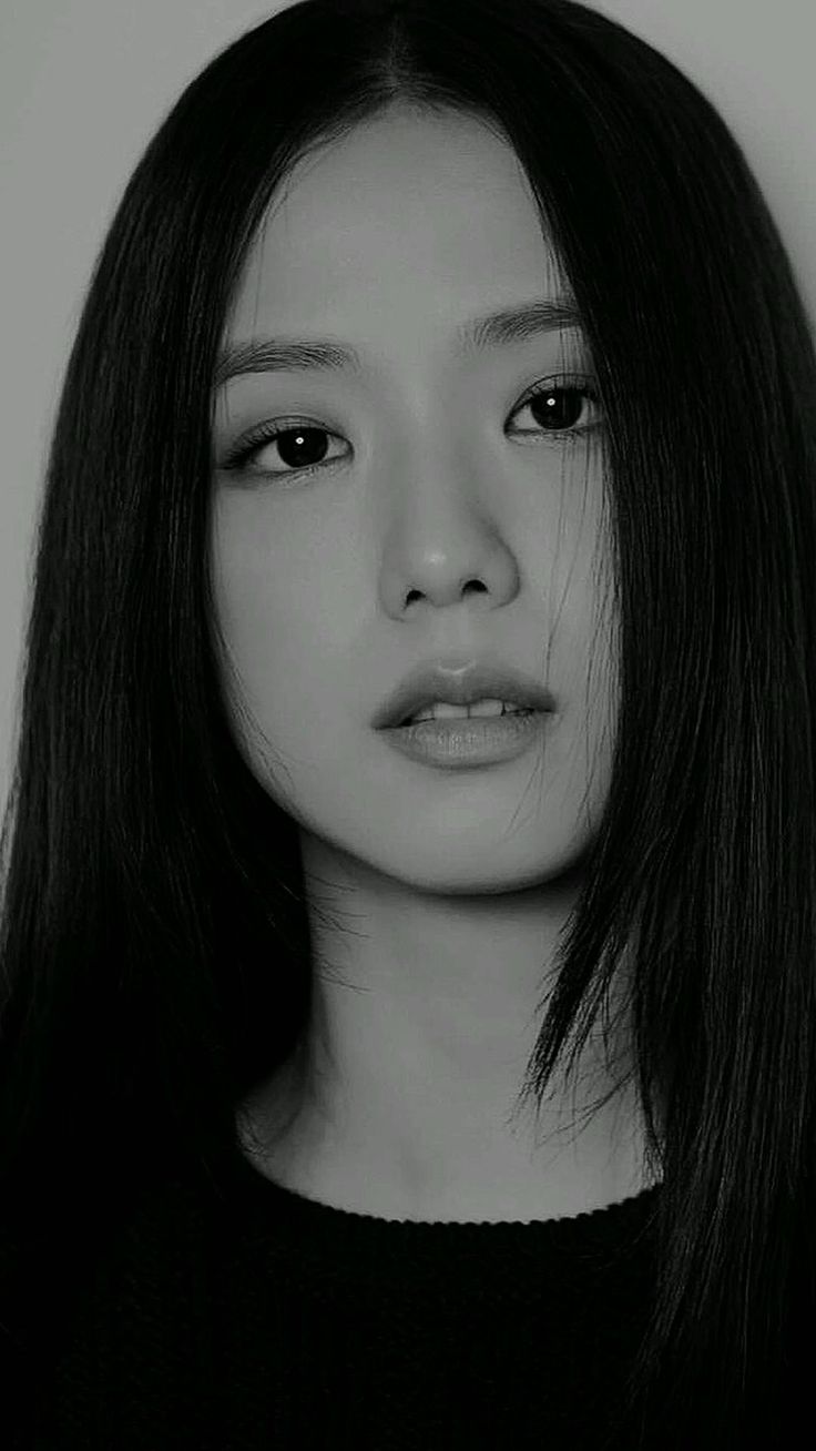 black and white photograph of a woman with long hair looking at the camera while wearing a sweater