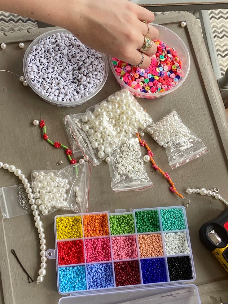 there are beads and other crafting supplies on the table