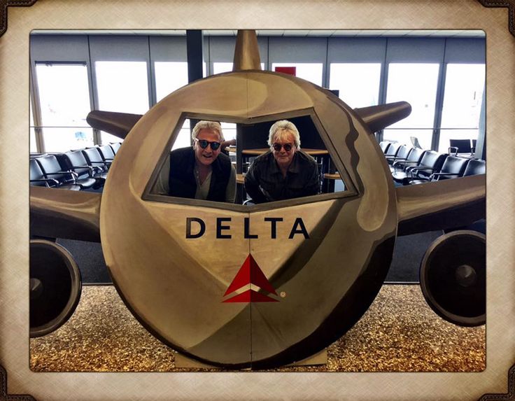 two men sitting in the cockpit of an airplane with delta logo on it's side