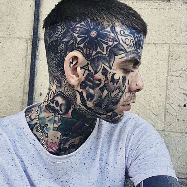 a man with tattoos on his face and neck