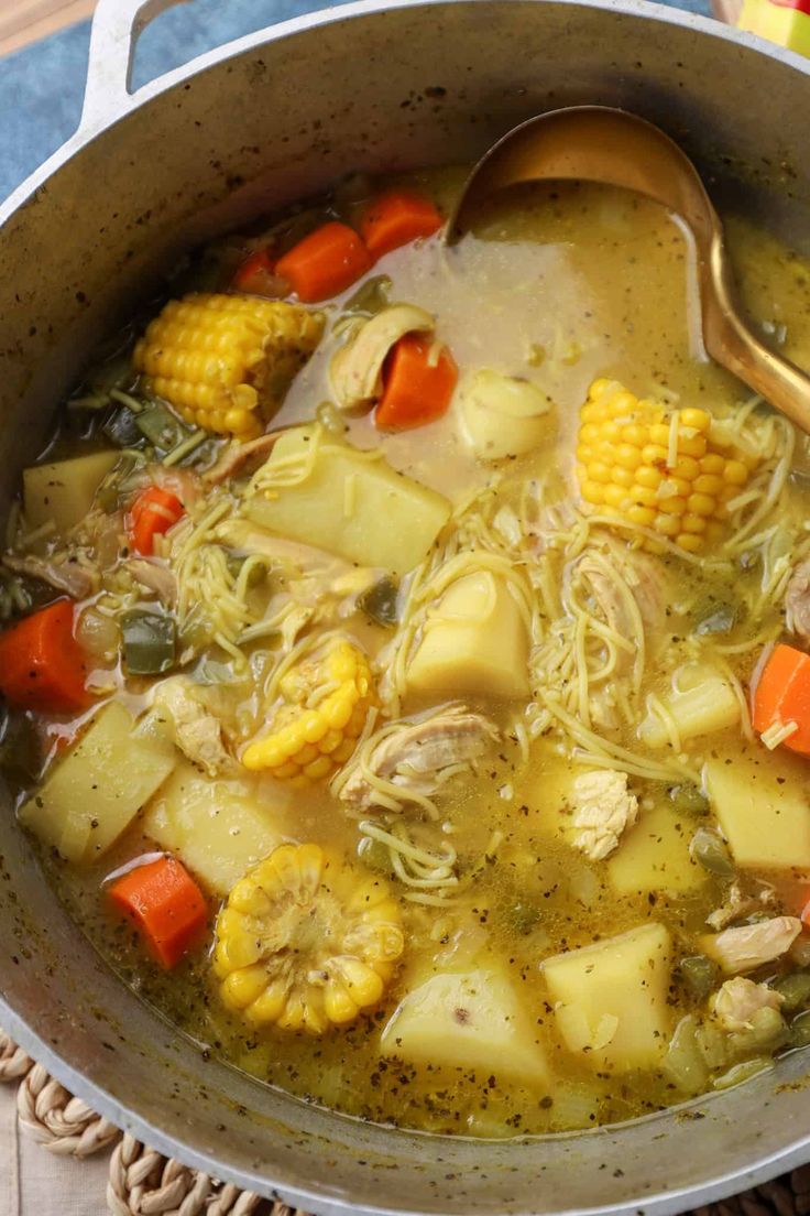 a pot filled with soup and vegetables on top of a table