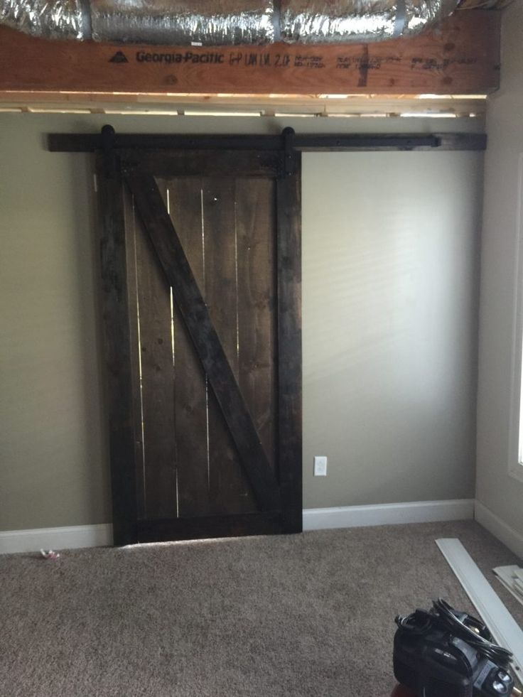 an unfinished room with a sliding door and carpet