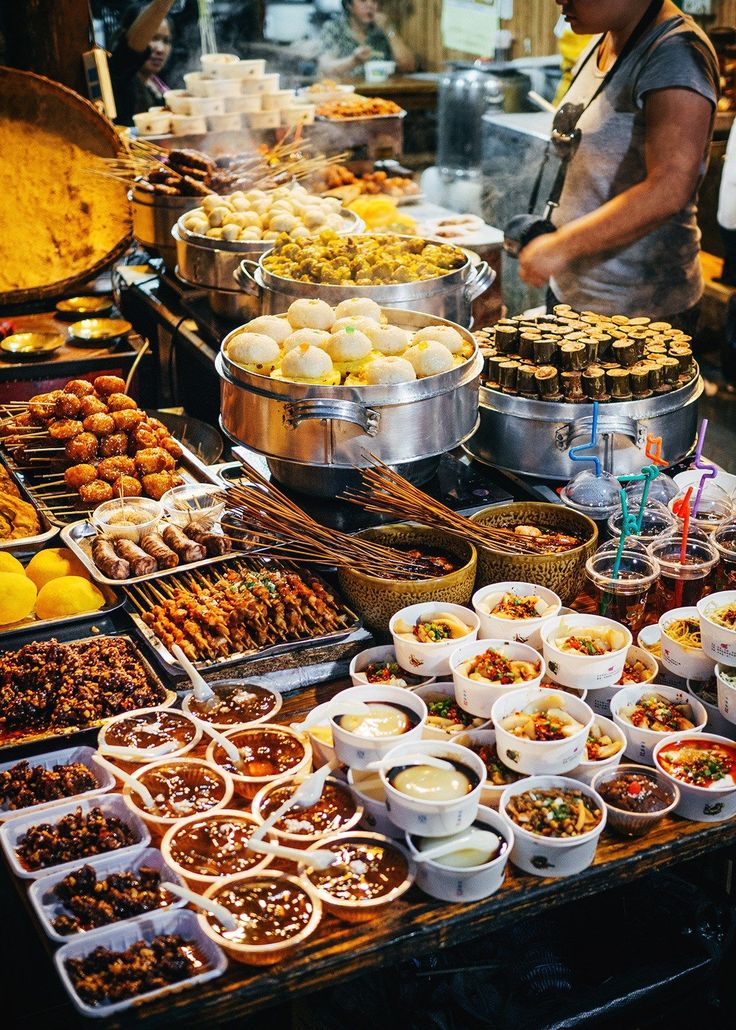 many bowls and trays of food on a table