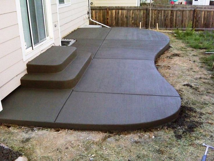 an outdoor patio with steps leading up to the back door and side of a house