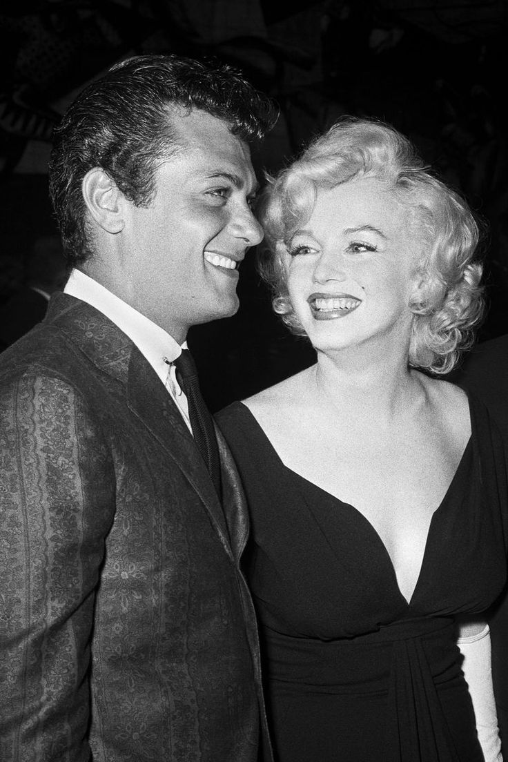 a black and white photo of two people smiling