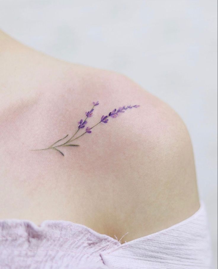 the back of a woman's shoulder with lavender flowers on it