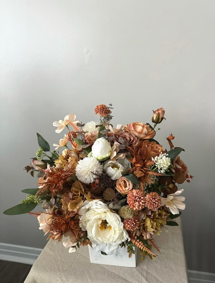 a vase filled with lots of flowers on top of a table