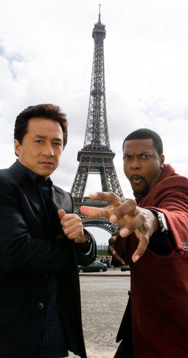 two men pointing at the camera in front of the eiffel tower