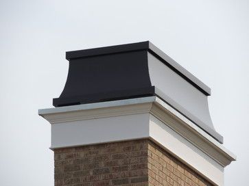 the top of a brick building with a black chimney