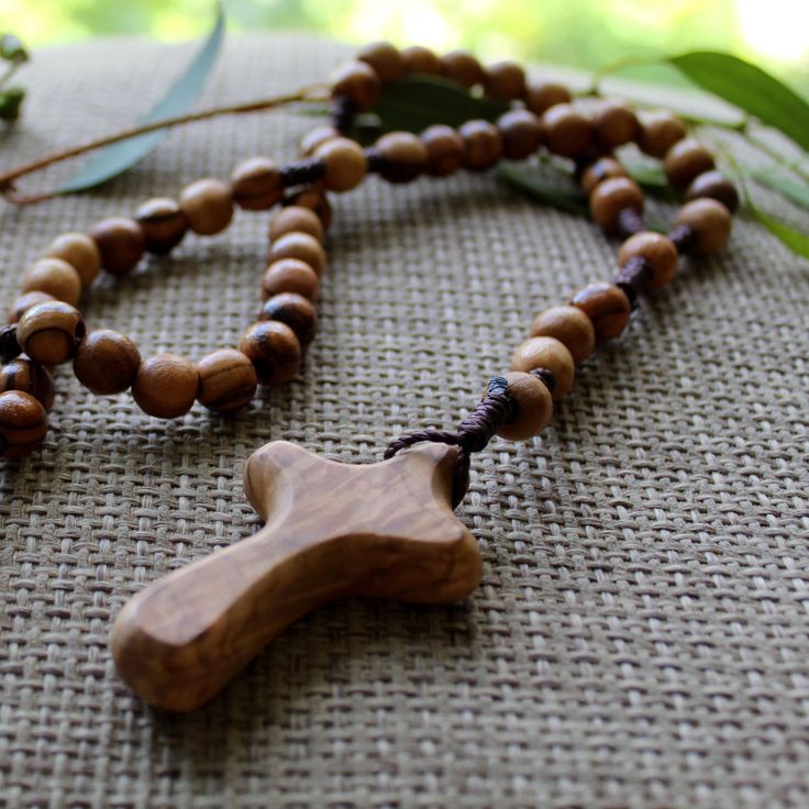 Were you looking for the perfect religious gift with symbolic meaning? This wooden rosary necklace is perfect for your Christian friend or family member. Made from grade A olive wood that grew on the soils of the Holy Land, this wooden rosary will warm the heart of whoever receives it. Whether for yourself or a gift for someone else, this wooden rosary from Jerusalem will serve as a reminder of your faith in the Lord, keeping it close to you and guiding you towards His loving presence and mercy. HANDMADE PIECE - Handcrafted in Jerusalem with genuine olive wood. PERFECT GIFT - Perfect gift to affirm someone's faith and remind them of the Lord's presence. GENUINE MATERIALS - Feel closer to God and His presence because the olive wood used for this rosary grew in the Holy Land. PRODUCT DIMENSI Wood Rosary Bracelet, Wooden Rosary, Olive Wood Cross, Necklace Christian, Christian Friends, Wood Cross, Rosary Necklace, Wood Crosses, Holy Land