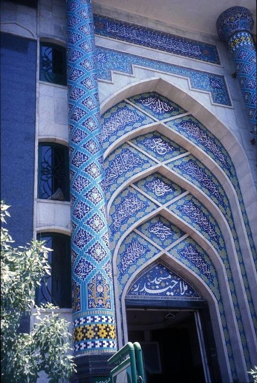 the entrance to an ornate building with blue and white tiles