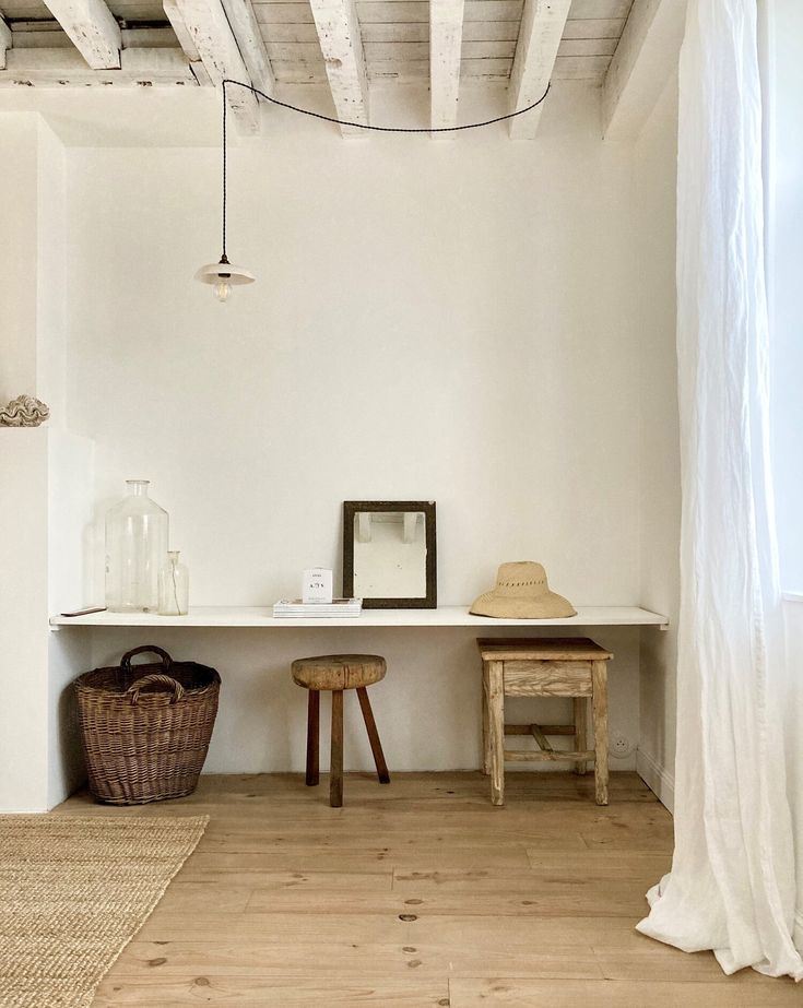 a white room with two stools and a table