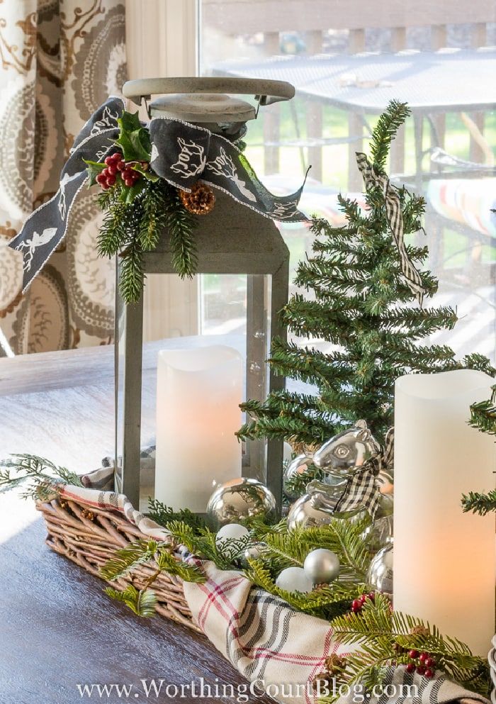 a christmas centerpiece with candles and ornaments