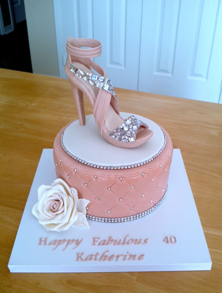 a birthday cake with a high heeled shoe and rose on the top, sitting on a table