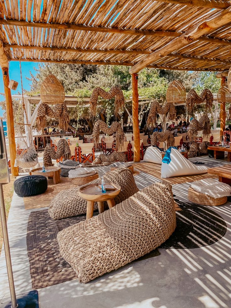 an outdoor seating area with wicker chairs and umbrellas