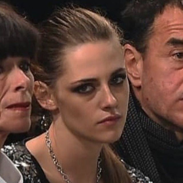 three people sitting next to each other at a fashion show