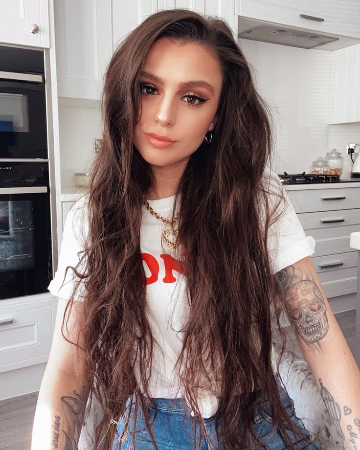 a woman with long hair standing in a kitchen