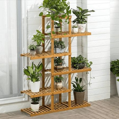 a wooden shelf filled with potted plants next to a window