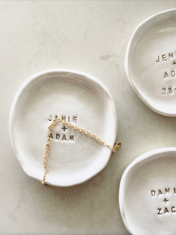 three white plates with names on them sitting on top of a marble countertop next to each other