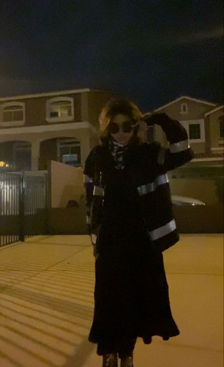 a woman standing on top of a skateboard in front of a house at night