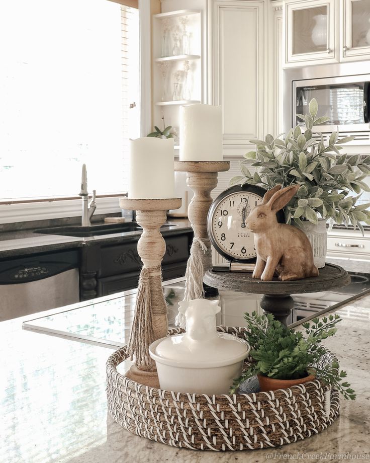 a clock sitting on top of a kitchen counter next to a basket filled with plants