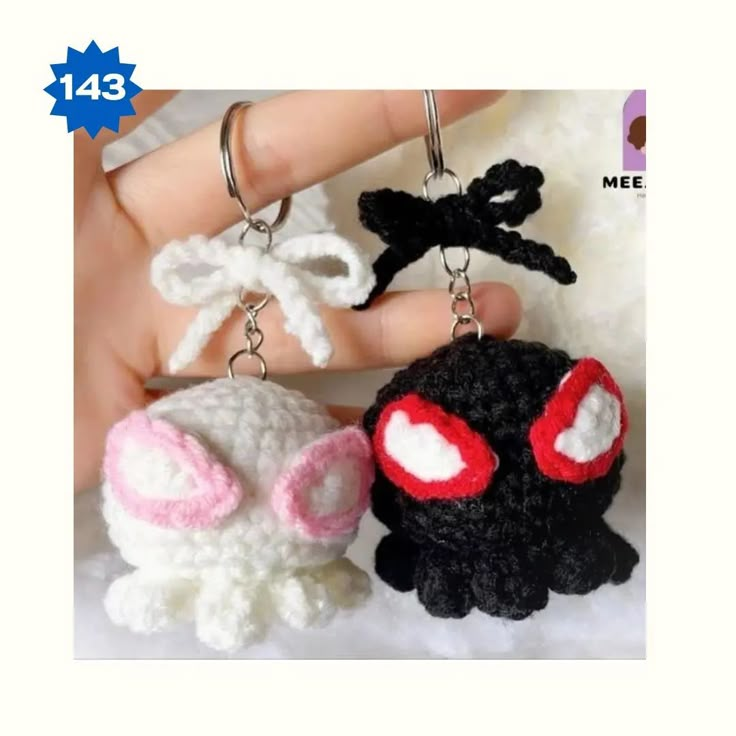 two crocheted keychains are being held up by someone's hand