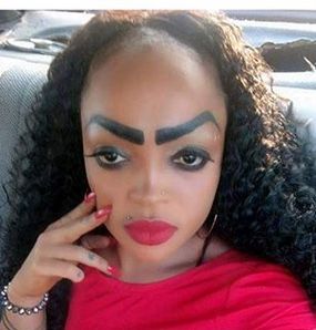 a woman with makeup on her face sitting in a car and looking at the camera