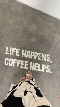 someone is standing on top of a coffee cup with the words life happens, coffee helps