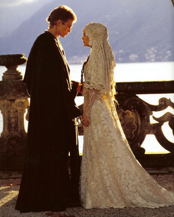 the bride and groom are looking at each other in front of a balcony overlooking mountains