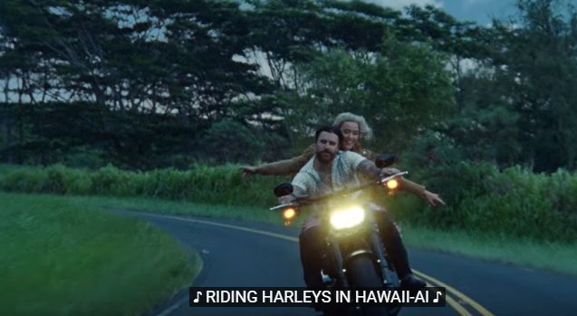 a man and woman riding on the back of a motorcycle down a curvy road