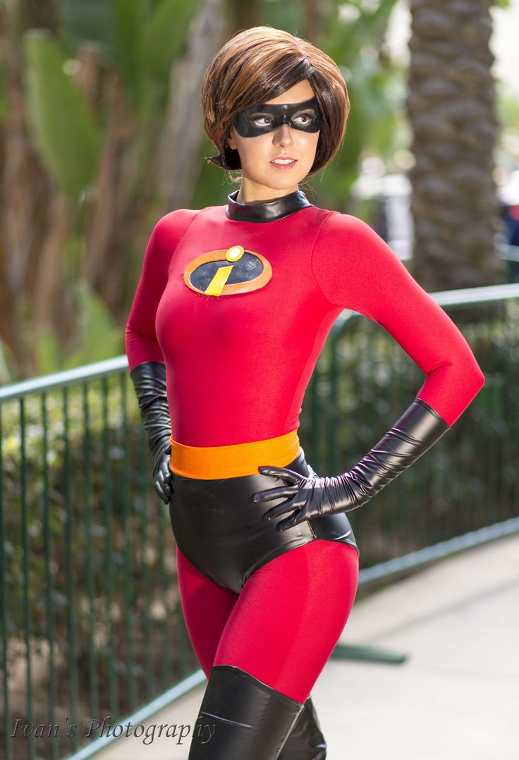 a woman in a red and black costume posing for the camera with her hands on her hips