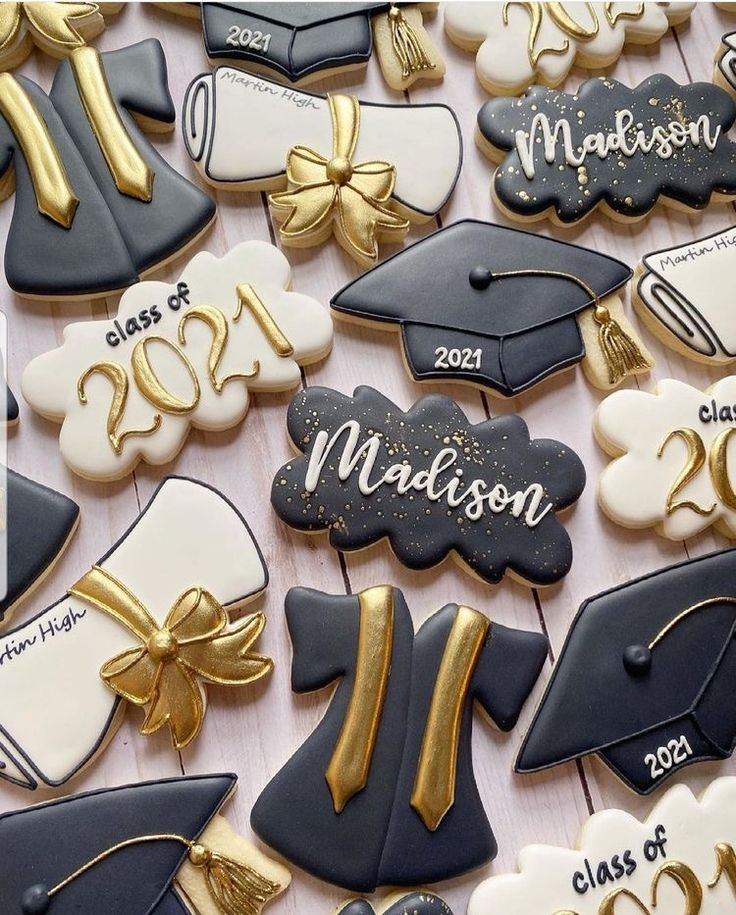 graduation cookies decorated with royal blue, white and gold icing are arranged on a table