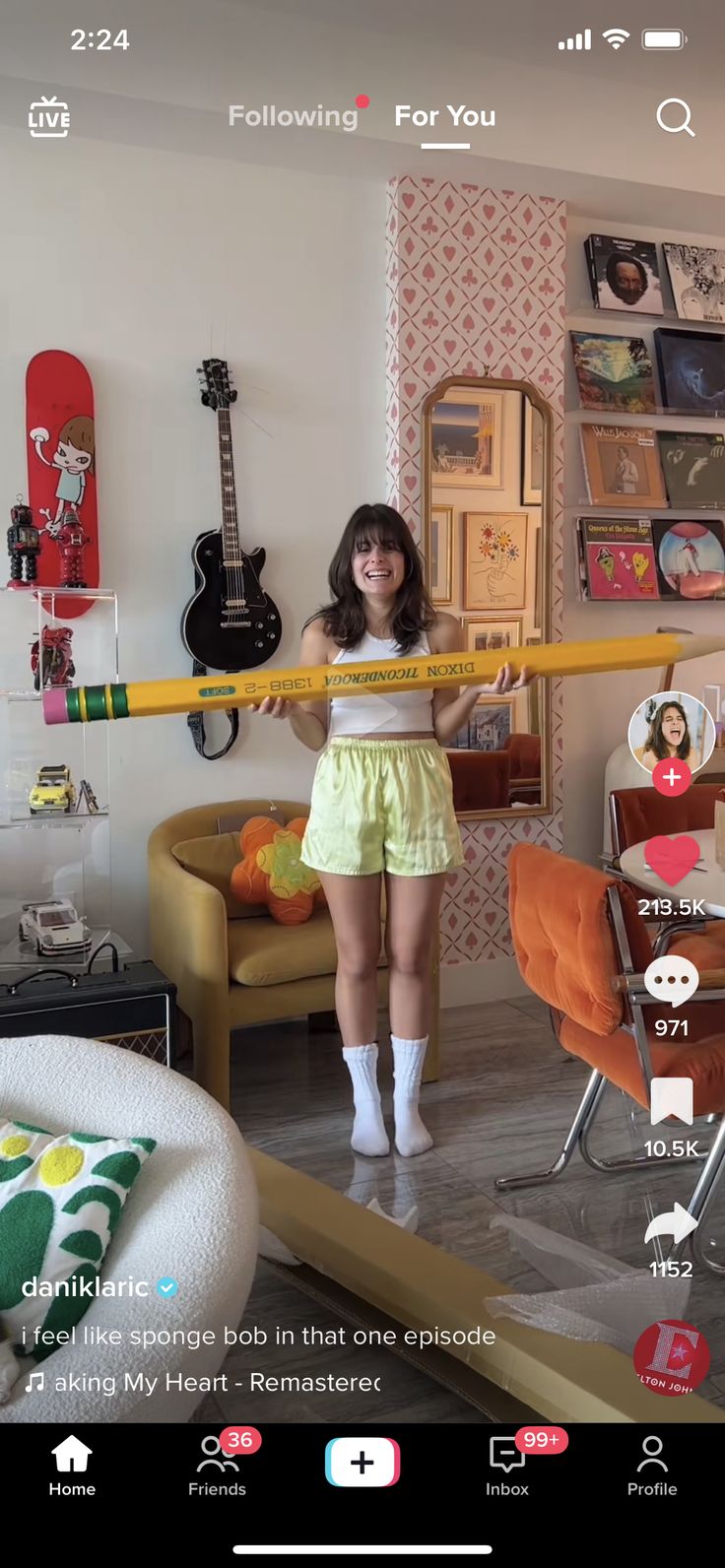 the girl is holding a giant pencil in her hand and standing next to an orange chair