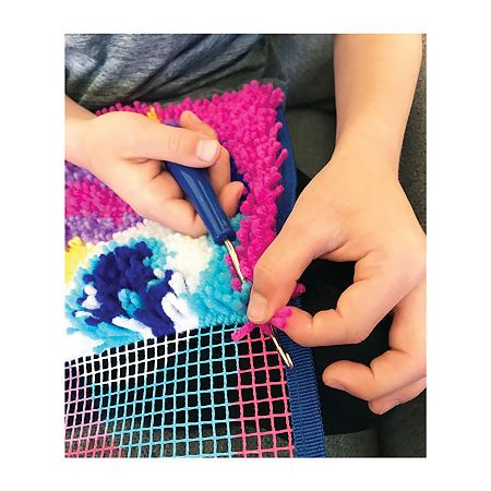 two hands are crocheting together to make a colorful piece of art with yarn