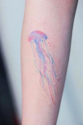 a small jellyfish tattoo on the arm