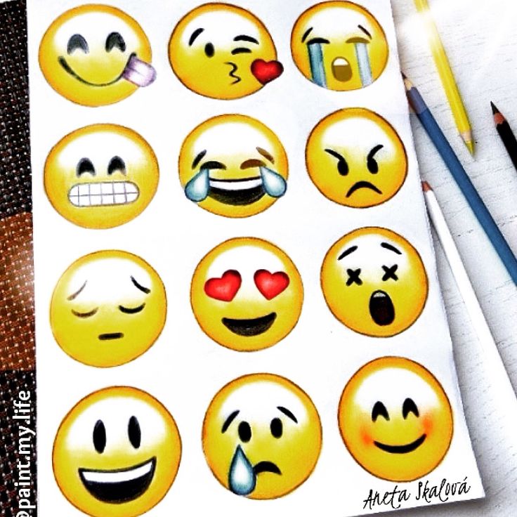 an assortment of smiley face stickers on top of a notepad with pencils next to it