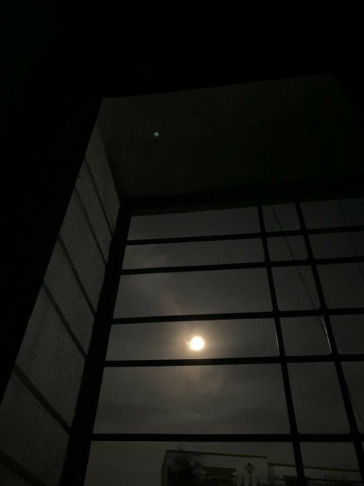 the moon is seen through an open window