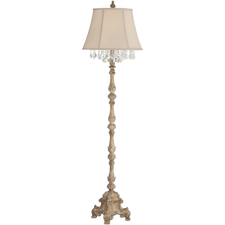 a floor lamp with a white shade on the top and a crystal beaded base