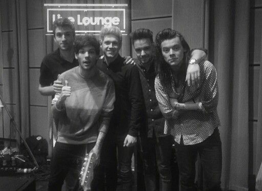 a group of young men standing next to each other in front of a recording studio