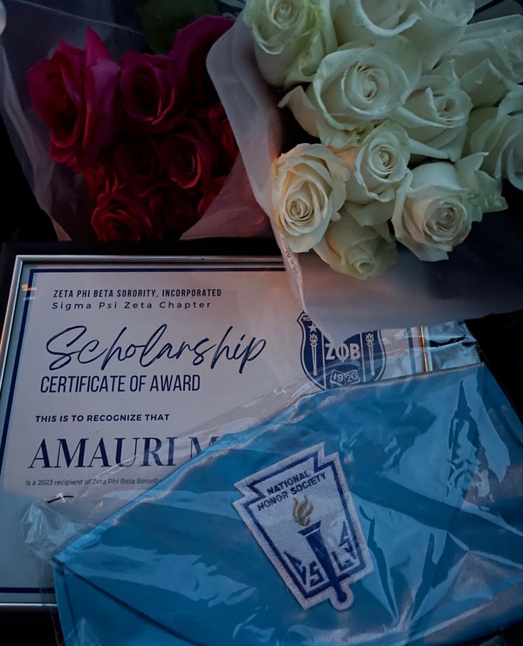 flowers and an award sitting on top of each other in front of a plaque that reads,