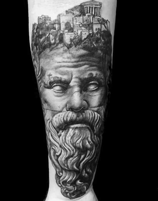 a man's leg with a black and white tattoo on it, depicting the face of an old man